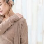 柏市・増尾で肩こりに悩み、肩を押さえる女性のイメージ