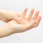 開いた手のひらを差し出す女性