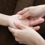 手のひらのツボを親指で押してもらう様子