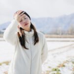 屋外で額に手を当てる女性